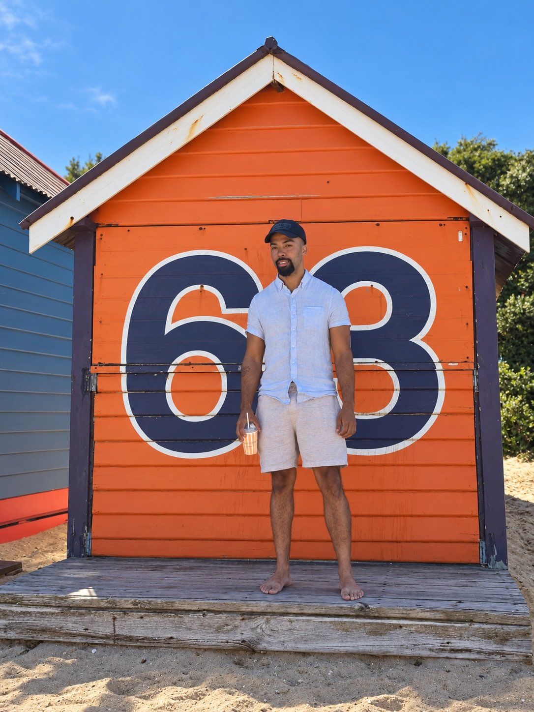 Anthony Nitti in front of an orange beach bathing box in Brighton